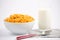 Natural corn flake breakfast cereal in cups and milk is a healthy breakfast that is good for your body every day on a white