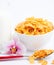 Natural corn flake breakfast cereal in cups and milk is a healthy breakfast that is good for your body every day on a white