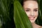 Natural Cosmetics. Beautiful Woman Face With Green Plant