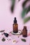 Natural cosmetics for face, body and hair care. Group of objects: glass bottles on a pink background with liquids or oil, near