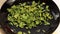 Natural dried parsley is sprinkled on a black saucer. Flavorful seasonings