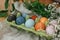 Natural dye easter eggs in carton tray on rustic table with flowers. Modern yellow, pink, blue and grey easter eggs painted with