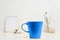 Natural eco home decor with cup coffee colored in trendy color of year 2020 Classic Blue near white workplace. Bright Macro color