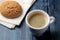 Natural espresso coffee in a ceramic coffee cup and cookies on a blue wooden table