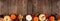 Natural fall border with pumpkins and leaves on a rustic dark wood banner background