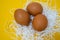 Natural food. Raw chicken eggs in a nest made of white paper on a yellow background. Low-calorie protein food