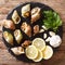 Natural French food: raw edible sea snails close-up and lemon, p