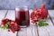 Natural, fresh pomegranate juice in a glass cup, in delicate colors, on a wooden background,