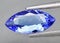 Natural gemstone blue tanzanite on gray background