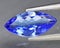 Natural gemstone blue tanzanite on gray background