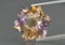 Natural gemstone colored ametrine in thongs on a gray background. Natural Bolivian bicolor yellow purple ametrine
