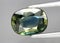 Natural gemstone green sapphire on gray background