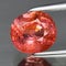 Natural gemstone orange hessonite garnet on gray background