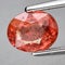 Natural gemstone orange Padparadscha sapphire on gray background