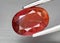 Natural gemstone orange Padparadscha sapphire on gray background