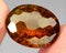 Natural gemstone wine imperial topaz on a gray background