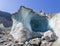 The natural glacial cave the glacier Mer de Glace with the Aiguilles towers in the background