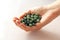 Natural green jade nephrite mineral stones beads. The green jade stone lies in the hands. Hands holding stone on white background