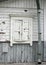 Natural grey and white old house wall with wood closed up white window, mailbox and tin waterpipe