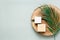 Natural handmade soap and wooden slab on a green background, top view. Cleanliness and hygiene concept.