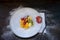 Natural and healthy fruit salad with orange set in a gourmet presentation plate on a rusticblack surface. Healthy Food Concept,