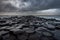 The natural hexagonal stones at the coast called Giant`s Causeway, a landmark in Northern Ireland with dramatic cloudy sky