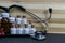 Natural Homeopathy Concept - A Stethoscope with Homeopathic medicine bottles consisting pills and liquid substance and pink flower