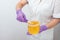 Natural honey sugar paste shugaring closeup. Women beautician holds jar wax of paste for sugar depilation shugaring