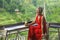 Natural lifestyle outdoors portrait of attractive and happy middle aged Asian Indonesian woman in stylish red dress enjoying