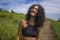 Natural lifestyle portrait of young attractive and happy hipster woman with curly hair in fitness clothes enjoying nature outdoors