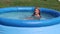 Natural lighting. bright sun. A girl in a swimsuit is swimming in a small pool. Close-up