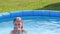 Natural lighting. bright sun. A girl in a swimsuit is swimming in a small pool. Close-up