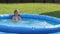 Natural lighting. bright sun. A girl in a swimsuit is swimming in a small pool. Close-up