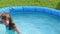 Natural lighting. bright sun. A girl in a swimsuit is swimming in a small pool. Close-up