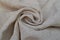 Natural linen fabric, twisted in the center into a spiral. Textile background