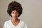 Natural looking young African woman standing against a gray background