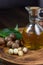 Natural macadamia oil in a glass bottle with macadamia nuts on wooden board.