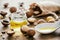 Natural macadamia oil and nuts on wooden board. Healthy product