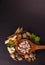 Natural medicine concept. Herbal drugs in a wooden spoon with different spices on black background and copy space