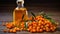 Natural oil of sea buckthorn Hippophae in glass bottle with branch of fresh, juicy ripe yellow berries with green leaves on a