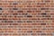 Natural old vintage weathered red brown solid brick wall. Abstract copy space background.