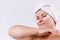 Natural older woman. With a towel on the head and pads under the eyes. Home skin care concept on white background.
