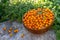 Natural organic ripe sea buckthorn berries in a wooden bowl on a stone in summer