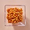 Natural organic sea buckthorn in the glass plate - yellow ripe sweet berries on a beige paper background. Top view.