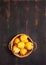 Natural pear fruit with defects in basket on dark wooden background