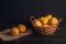 Natural pear fruit with defects in a basket on a jute napkin and a dark wooden background