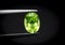 Natural Peridot Gems Stone oval cut beautiful.Holding a green stone by tweezers