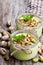 Natural pistachio yogurt in a small glass jar on wooden table