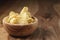 Natural potato chips with black pepper in wood bowl on table with copy space