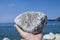 Natural pumice stone in hand on sea background